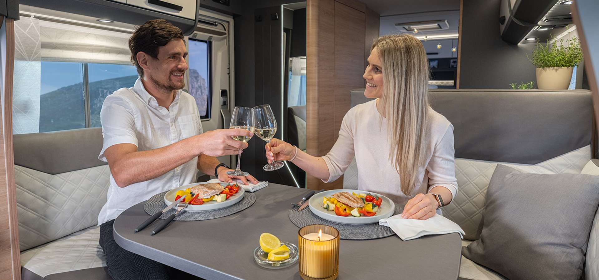 Couple qui mange dans un camping-car lors d'une soirées romantique